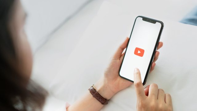 Foto: Shutterstock. Bilde av person som starter en Youtube-film på mobiletelefon.