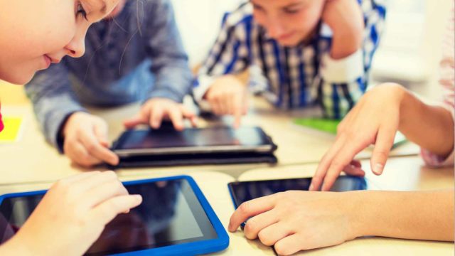 Foto: Shutterstock. Barn som bruker nettbrett på skole.