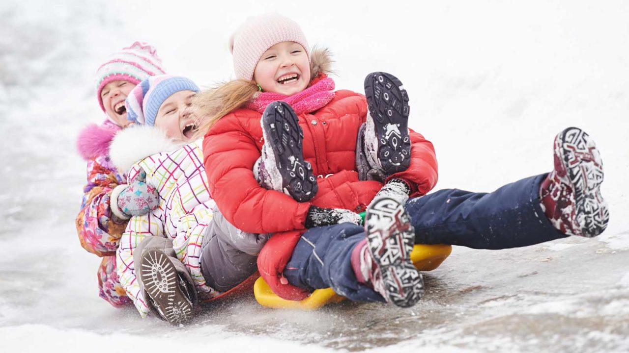 Tre barn på akebrett. Foto: Shutterstock