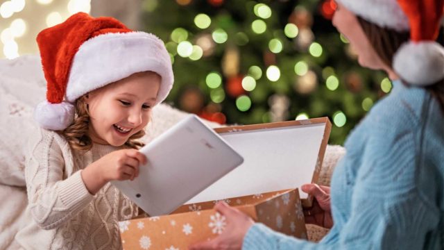 Foto: Shutterstock / Alexander Safonov. Bildet viser ei jente som får nettbrett i julegave.