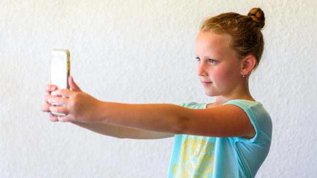 Foto: Shutterstock / Inna Reznik. Bildet viser ei jente som tar selfie.