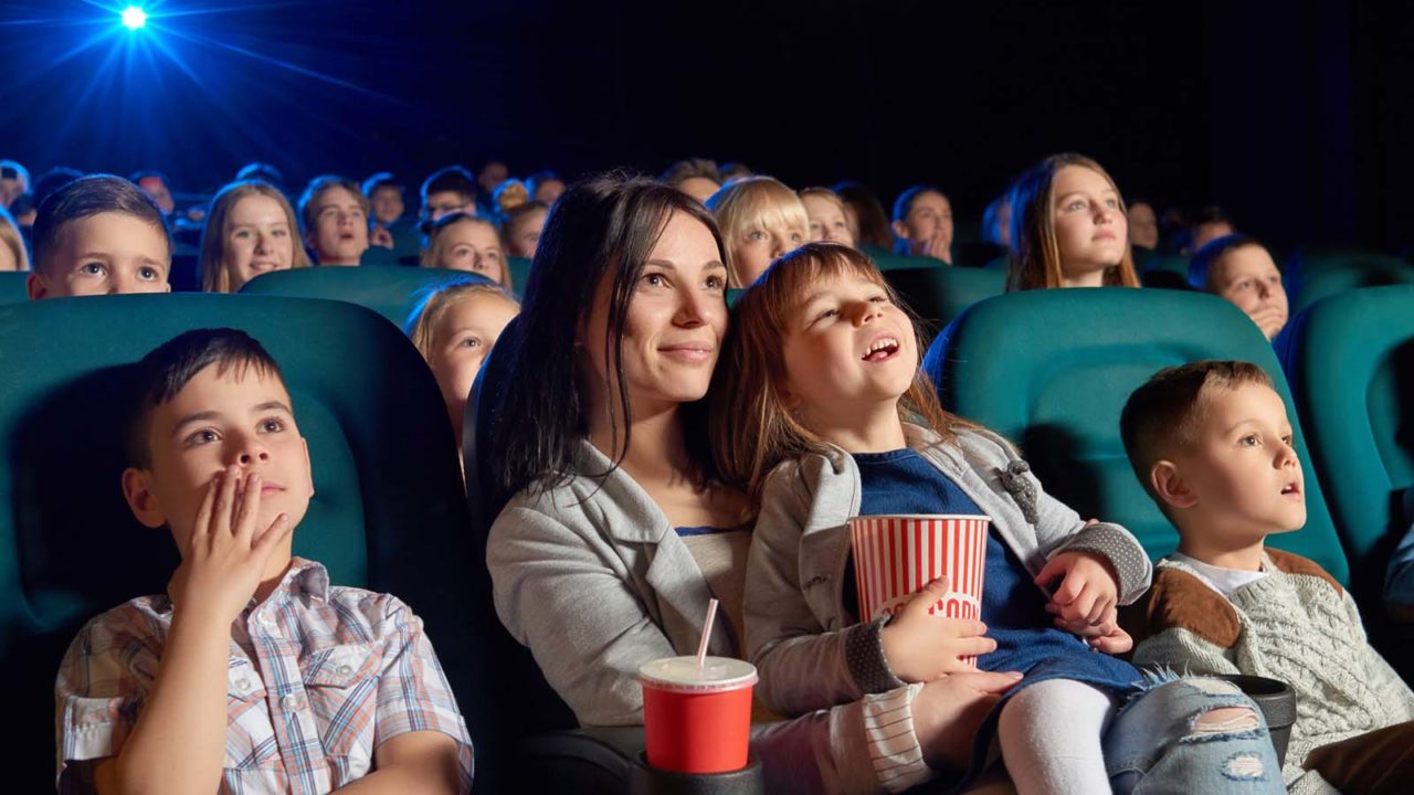 Foto: Shutterstock. Bildet viser en mamm som er på kino med sine barn.