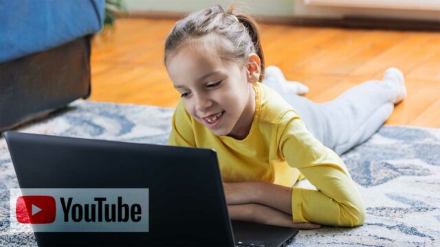 Foto: Shutterstock / Marija Ignjatovic / Barnevakten. Bildet viser ei jente som ligger på stuegulvet og ser på skjermen til en PC. Oppå bildet ligger en Youtube-logo.